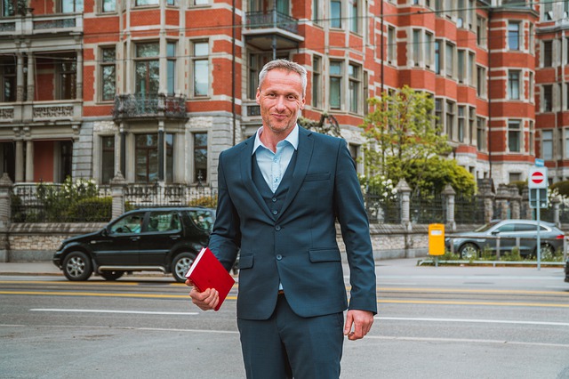 Real estate agent holding a notebook in his right arm